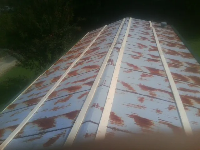 Rusted metal roof panels with new wood purlins before replacement — Storm Damage Roof Repair in Brockton by Roofing Brothers