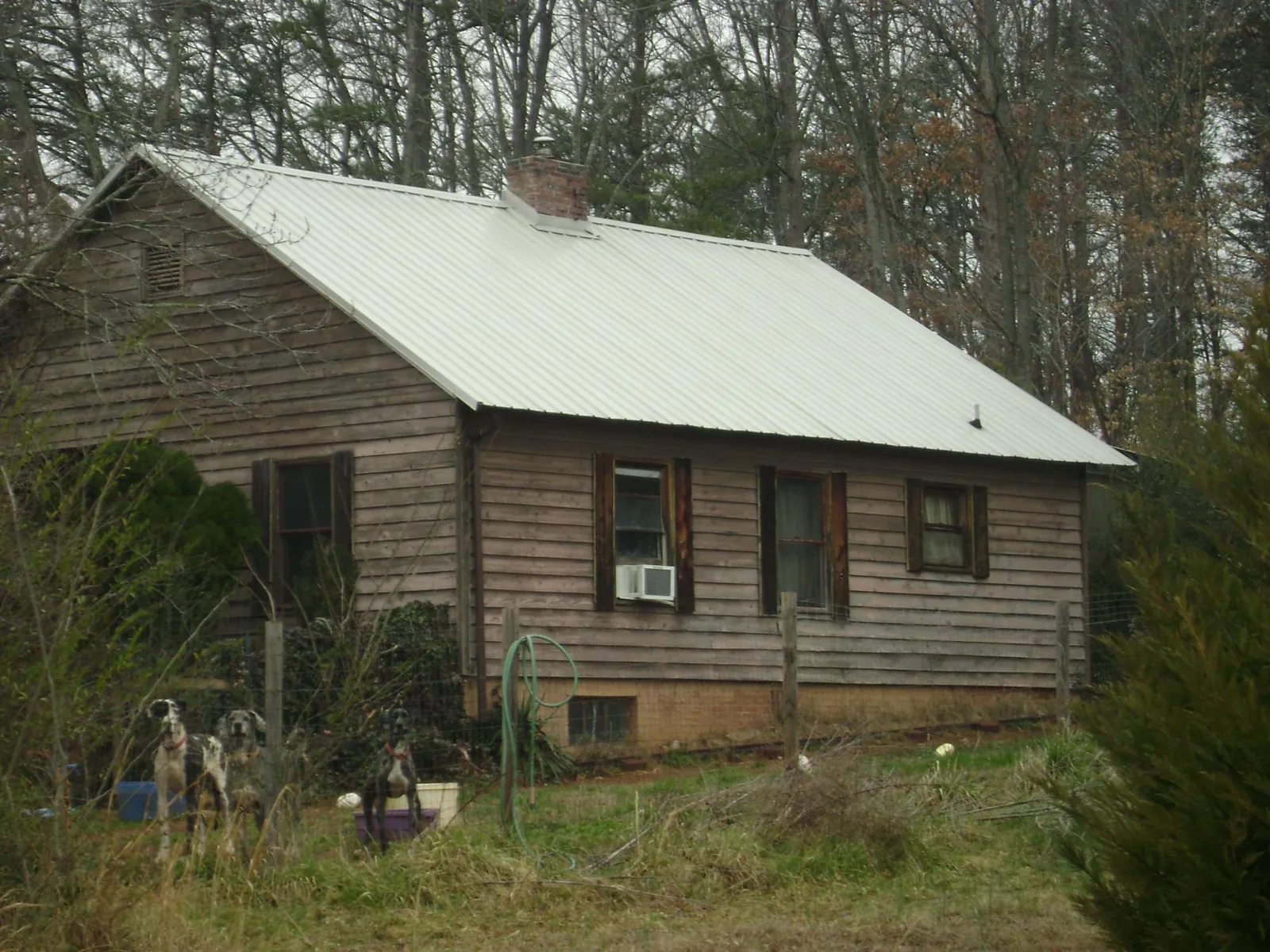 White metal roof on an old wood sided farmhouse, from a Metal Roof Installation job in Brockton